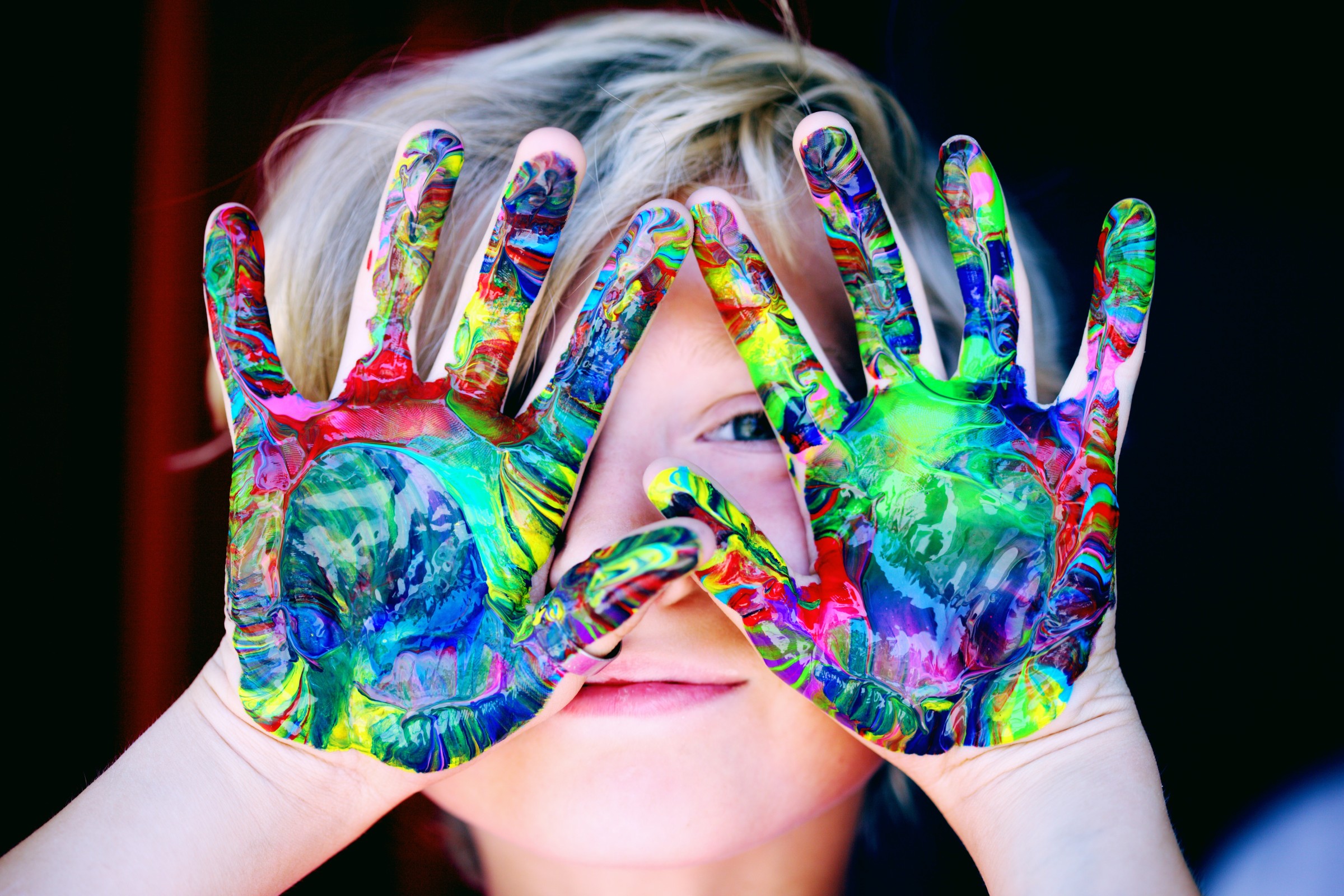 kid with swirled paint on hands