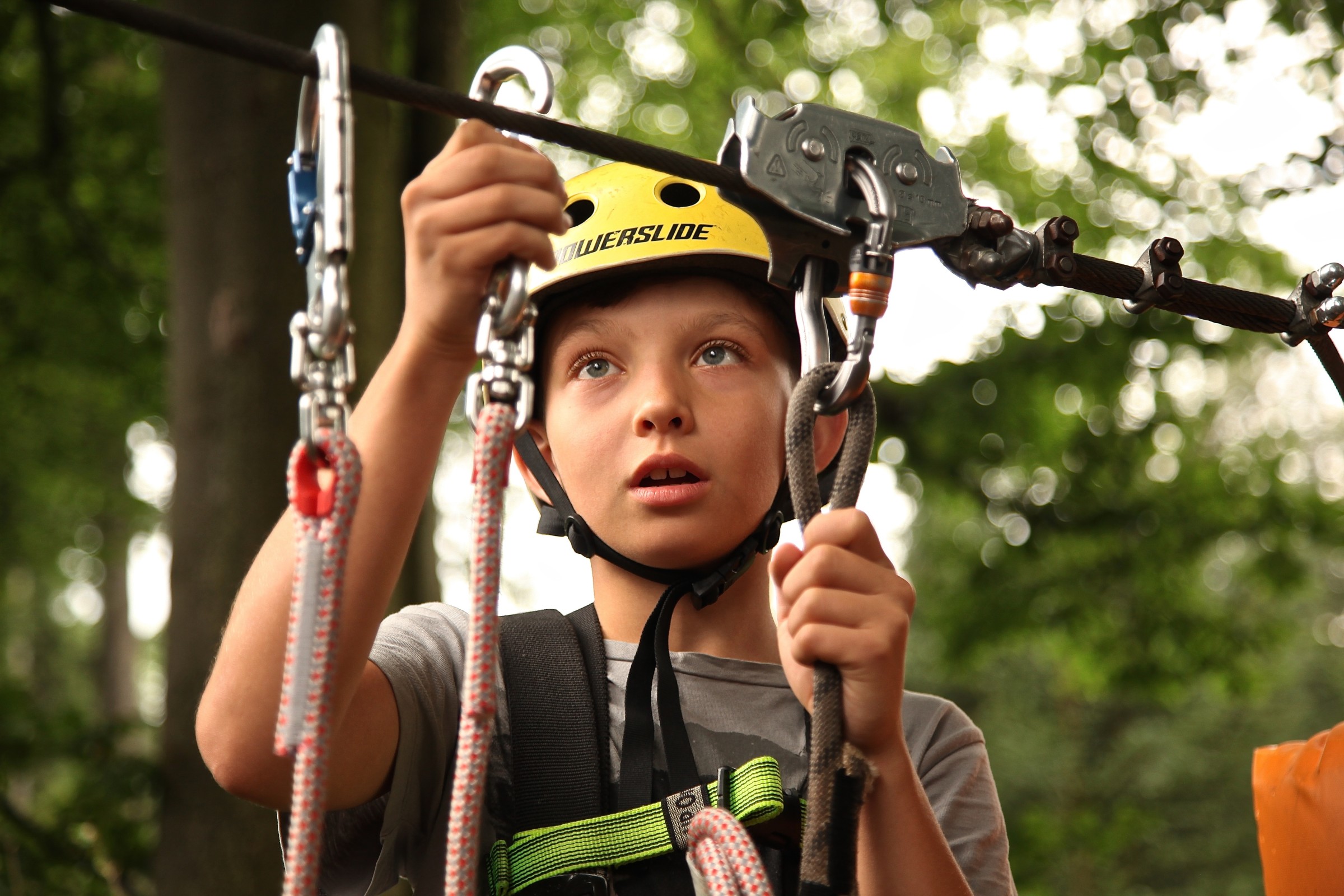 Kid clipping onto a zipline.